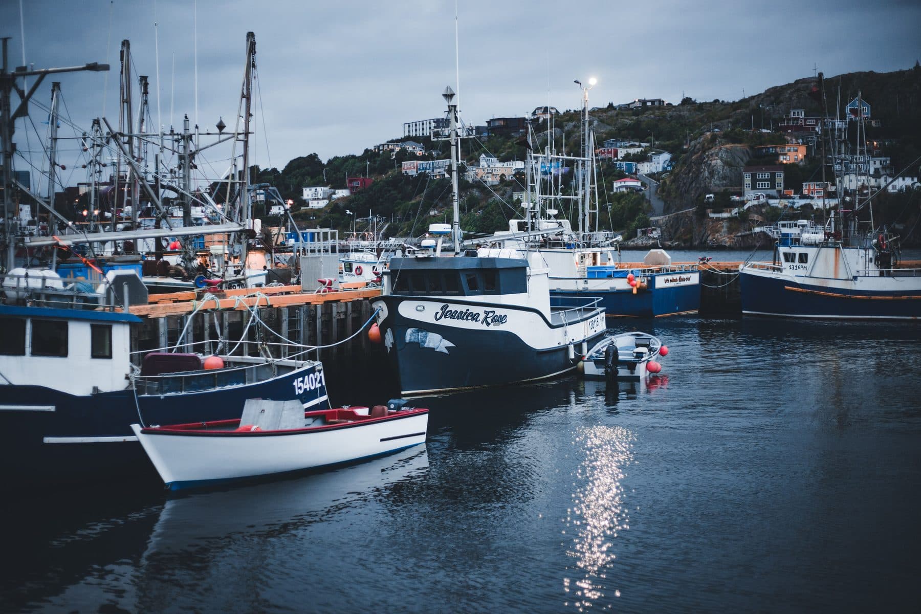 Fishing boats moored at a working Maine harbor at dusk